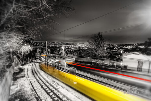 Schwarzweiss-Aufnahme an der Wielandshöhe, Stuttgart mit der Zahnradbahn in Form eines gelben Lichtschweifs.