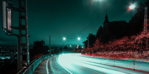 Nachtaufnahme an der Weinsteige in Stuttgart. Lichtschweif des Verkehrs in einer grün/blau roter Stimmung