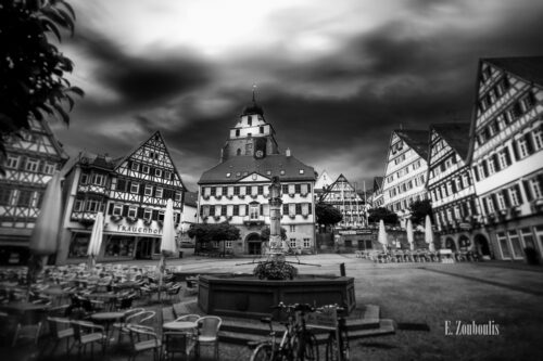 Schwarzweiß-Aufnahme am Marktplatz in Herrenberg. Im Vordergrund der Brunnen vor dem Rathaus der Stadt