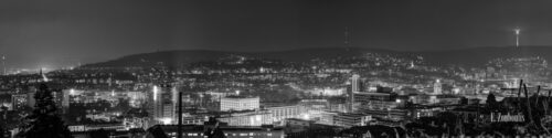 Nächtliches Schwarzweiß Panorama von Stuttgart. In der Mitte des Bildes befindet sich die Stadtbibliothek und die Innenstadt. Rechts am Bildrand ist der Fernsehturm zu sehen