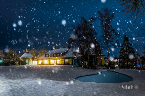 Nachtaufnahme an der Villa Schwalbenhof in Gärtringen. Im Vordergrund Schnee und der eingefrorene Teich. In der Mitte des Bildes die Villa bei einer Veranstaltung