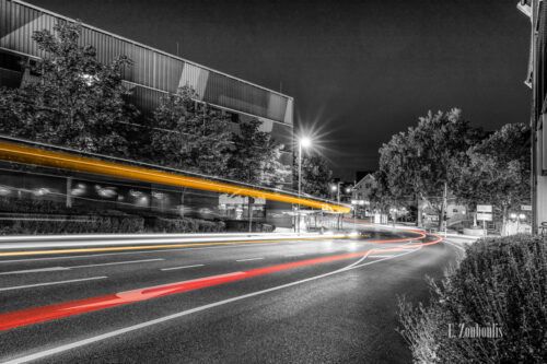 Schwarzweiss-Aufnahme an der Schwabengalerie in Vaihingen, Stuttgart mit Blick auf das Bürgerbüro. Im Vordergrund hinterlässt der Verkehr gelbe und rote Lichtschweife